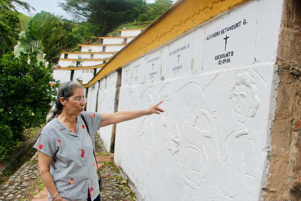 Sr. Teresita Cano points out the bas relief sculpture of Alejandro Betancur, one of 235 that line the walls of the ossuary looking out over Trujillo from the Monument Park for Memory. (Tracy L. Barnett)