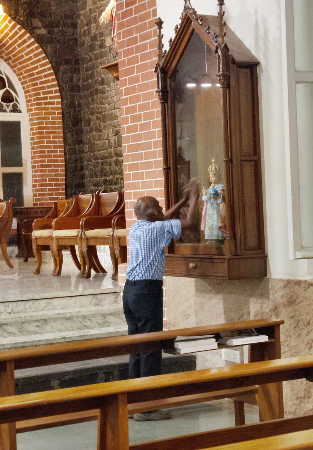 En iglesias, templos y mezquitas la fe se vive con una intensidad íntima y personal, como esta muestra de religiosidad popular de un hombre que reza en la parroquia católica San Francisco Javier de Pune. (Foto: Consuelo Vélez)