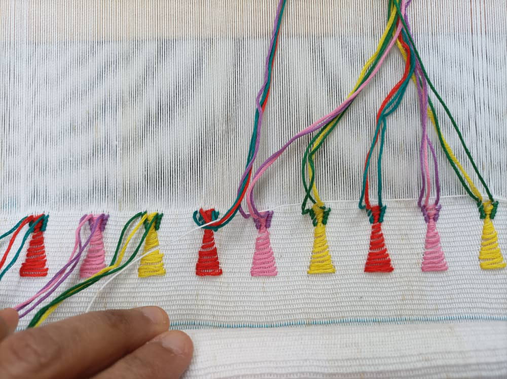 Small patterns incorporated into Lourdes Munguia's weaving work done on a loom (Courtesy of Lourdes Munguia) Small red, pink and yellow patterns incorporated into Lourdes Munguia's weaving work done on a loom (Courtesy of Lourdes Munguia)