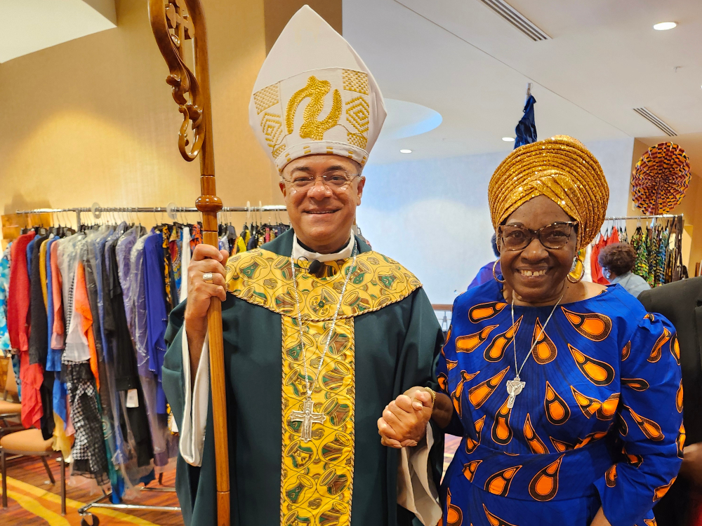 Sr. Jannette Pruitt and Archbishop Shelton Fabre of Louisville, Kentucky. Pruitt designed and created her dress, as well as Fabre's vestments. (Courtesy of Jannette Pruitt) Sr. Jannette Pruitt, dressed in a blue dress with large orange drop-shaped spots and a gold colored headwrap, and Archbishop Shelton Fabre of Louisville, Kentucky dressed in a green and yellow vestments with a white, gold-embroidered mitre.