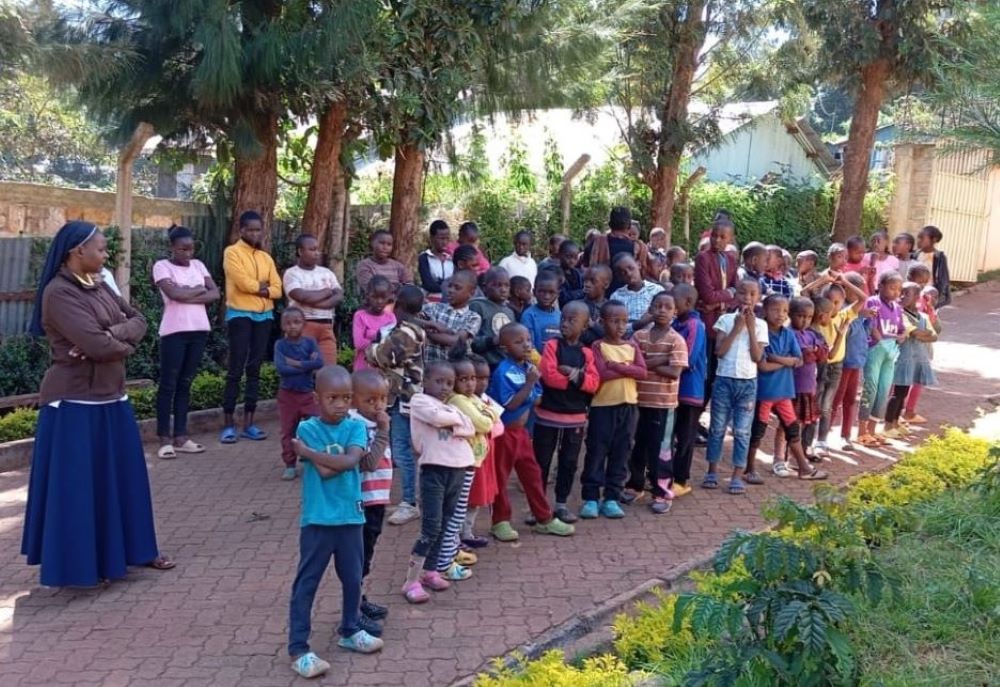 Sr. Justicia Nekesa stands with a group of children. Sr. Justicia Nekesa stands with a group of children.