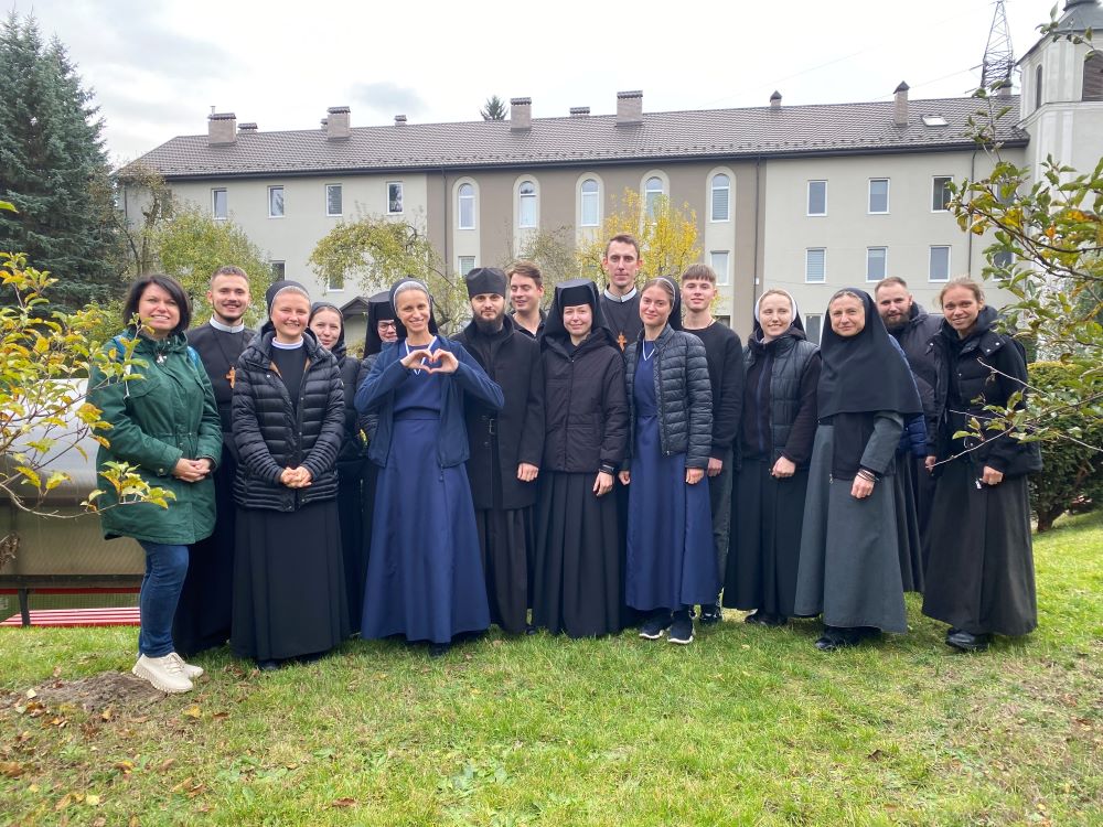 A group of novices stand outside a building.