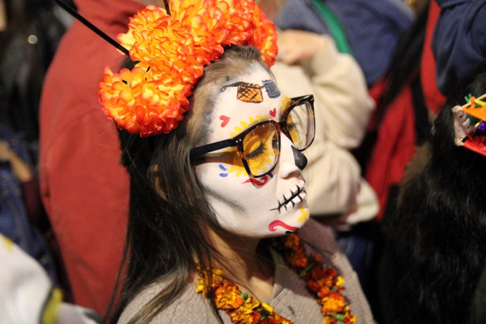 A woman dressed up as "La Catrina," a Mexican character also known as "The Elegant Death" watches the La Catrina parade in Mexico City Oct. 26.