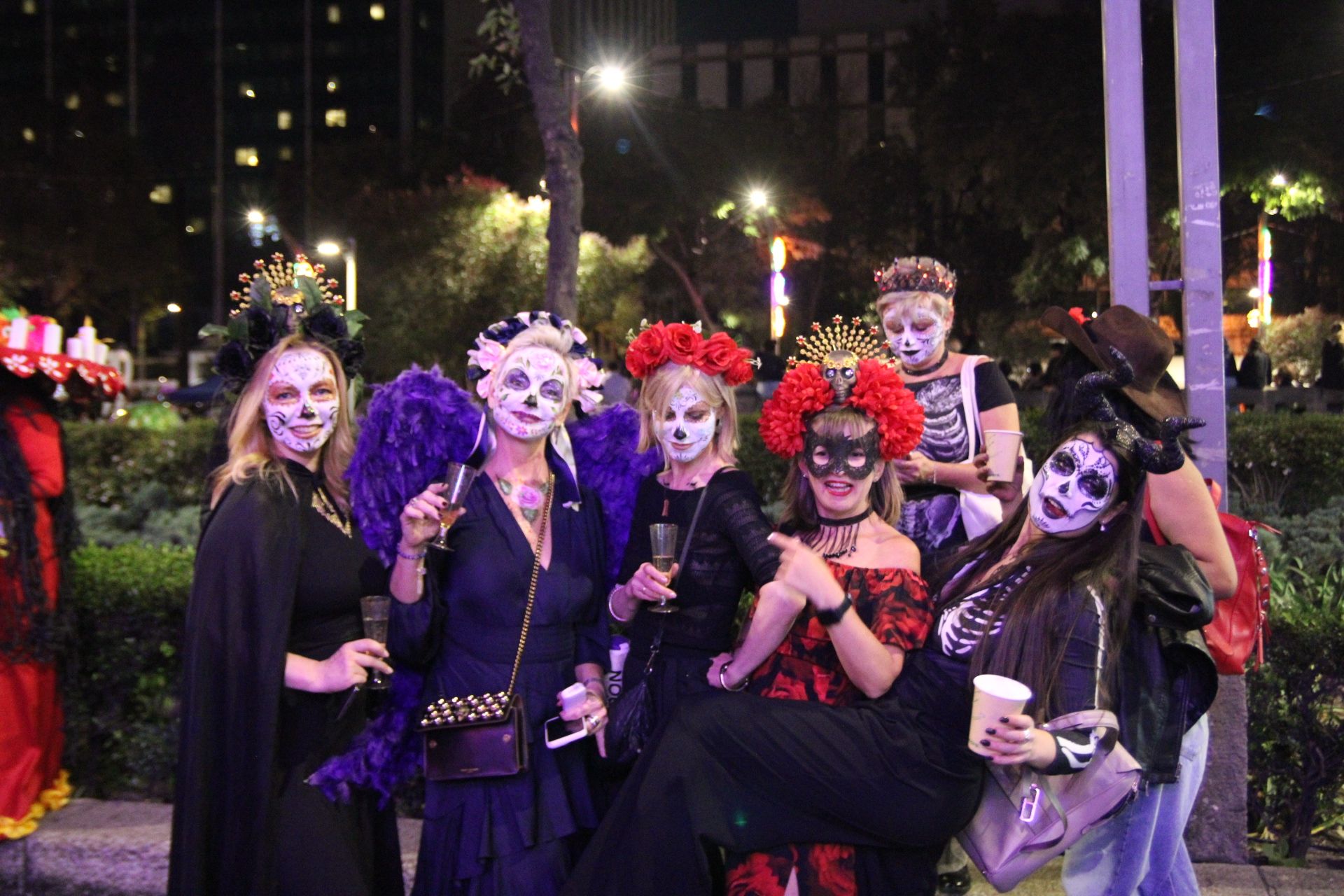 Mujeres jóvenes disfrazadas y maquilladas posan durante el Desfile de las Catrinas en la noche del 26 de octubre de 2025 en la Ciudad de México. (Foto: Helga Leija/GSR en español)