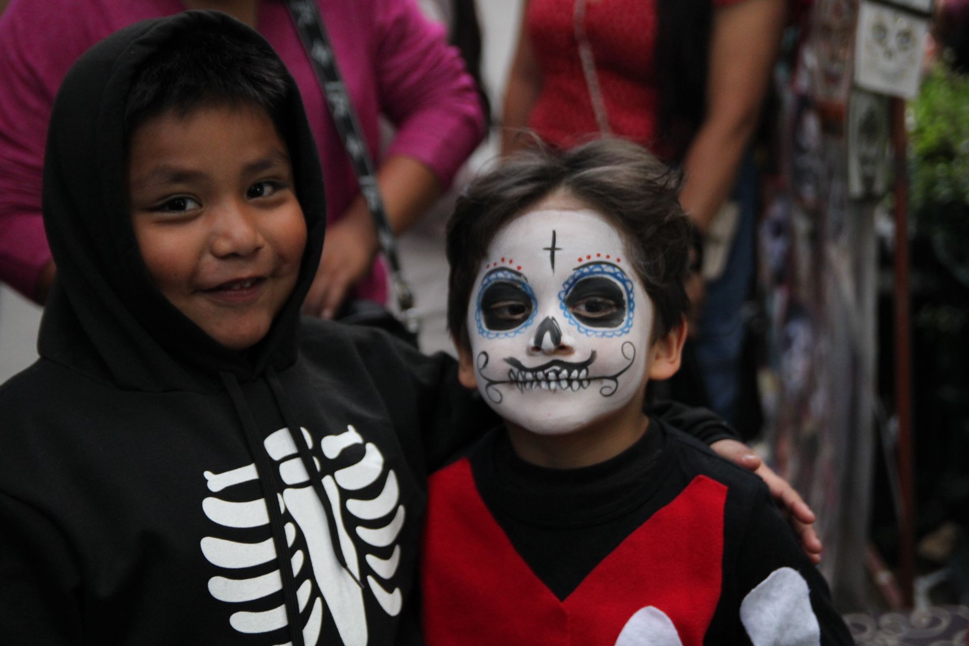 Dos niños, uno con el rostro pintado como catrina, se preparan para ver el Desfile de las Catrinas el 26 de octubre de 2025 en la Ciudad de México. (Foto: Helga Leija/GSR en español)