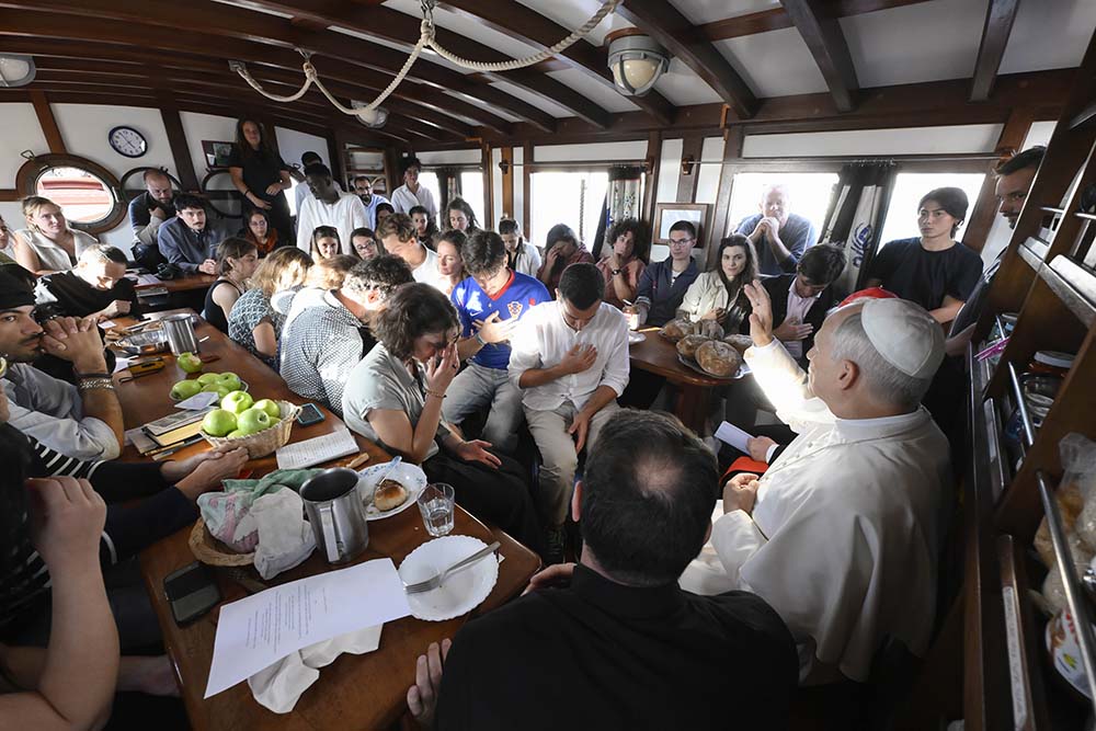 Pope Leo XIV gives his blessing to young adults aboard the "Bel Espoir" sailboat in the Ostia marina outside Rome Oct. 17, 2025. In rotating crews of 25, young adults have been sailing around the Mediterranean to speak about peace with their peers. (CNS/Vatican Media)