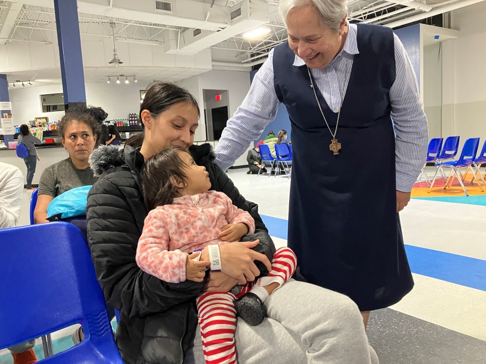 Missionary of Jesus Sr. Norma Pimentel greets Esther Chicas, a recently arrived migrant from El Salvador, and her child, Andrea, at the Humanitarian Respite Center in McAllen, Texas, on Nov. 11, 2023. 