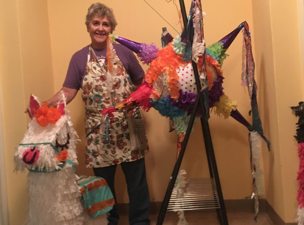Woman stands with pinatas.