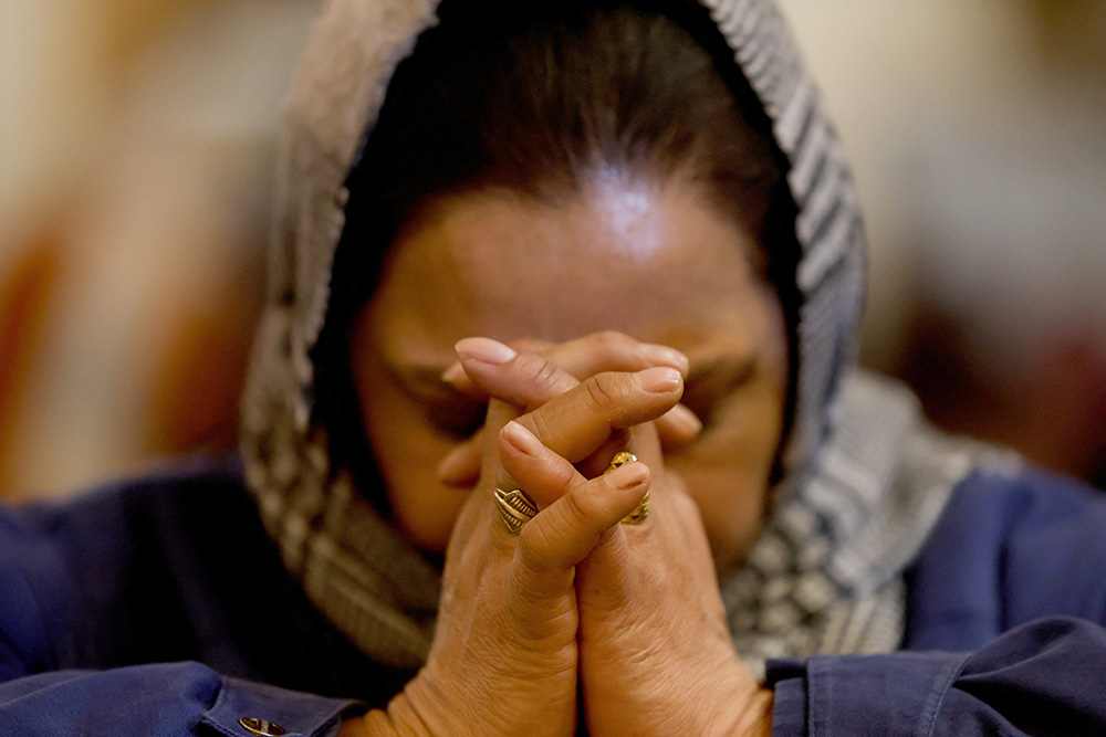 A woman prays during Christmas Eve Mass at Holy Family Catholic Church in Srinagar, India, Dec. 24, 2025. (OSV News/Reuters/Sharafat Ali)