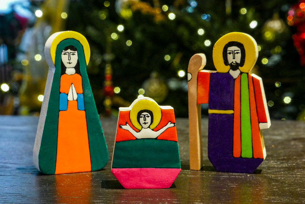 La Palma folk art nativity with Jesus, Mary and Joseph, against a backdrop of Christmas lights (Unsplash/Mick Haupt)