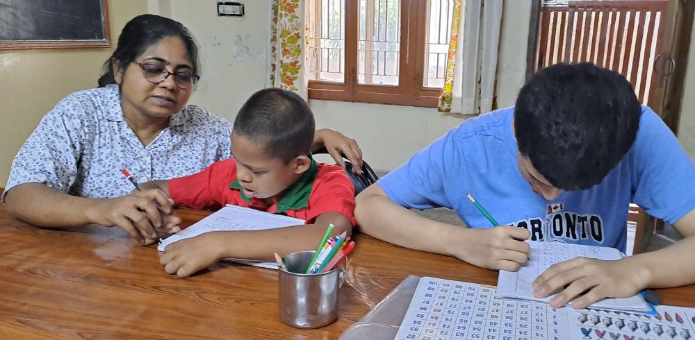 Marist Missionary Sr. Suporna Rozario teaches two children with disabilities at a center in Bangladesh. Rozario administers two centers in Dhaka, which serve 51 people (mostly children) with disabilities. (Courtesy of Suporna Rozario)