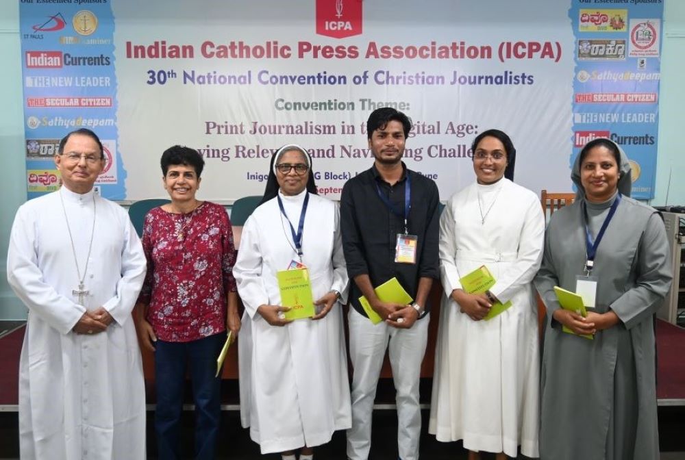Sr. Soniya K. Chacko (second from right), a member of the Daughters of Charity of St. Vincent De Paul, is welcomed into the Indian Catholic Press Association by Bishop Henry D'Souza of Bellary, the ecclesiastical adviser to ICPA, during the association's 30th national convention at Pune, western India, on Sept. 20, 2025. (George Kommattam)