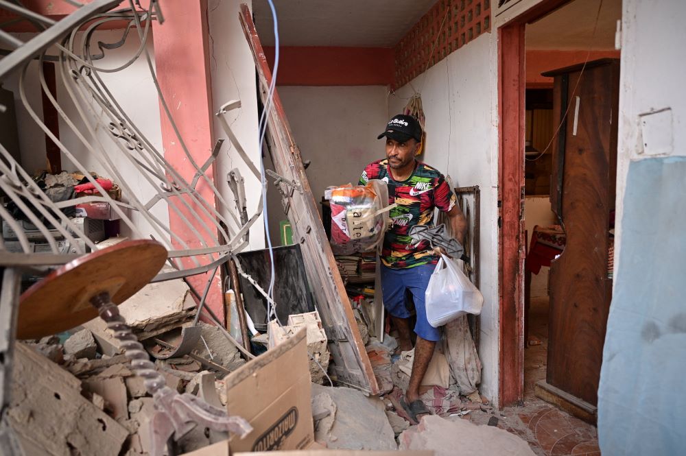 Jonathan Mayora collects items from his damaged family home in Catia La Mar, Venezuela, Jan. 4, after the U.S. launched a strike on Venezuela, capturing President Nicolas Maduro and his wife Cilia Flores. (OSV News/Reuters/Gaby Oraa)