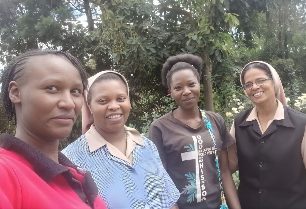 Sr. Alphonsa Parathur (right) and Sr. Verah Mwango (second from left) pose with two former residents of the Holy Family Children's Home. The home in Nakuru, Kenya, accommodates 100 children. (Courtesy of Alphonsa Parathur)