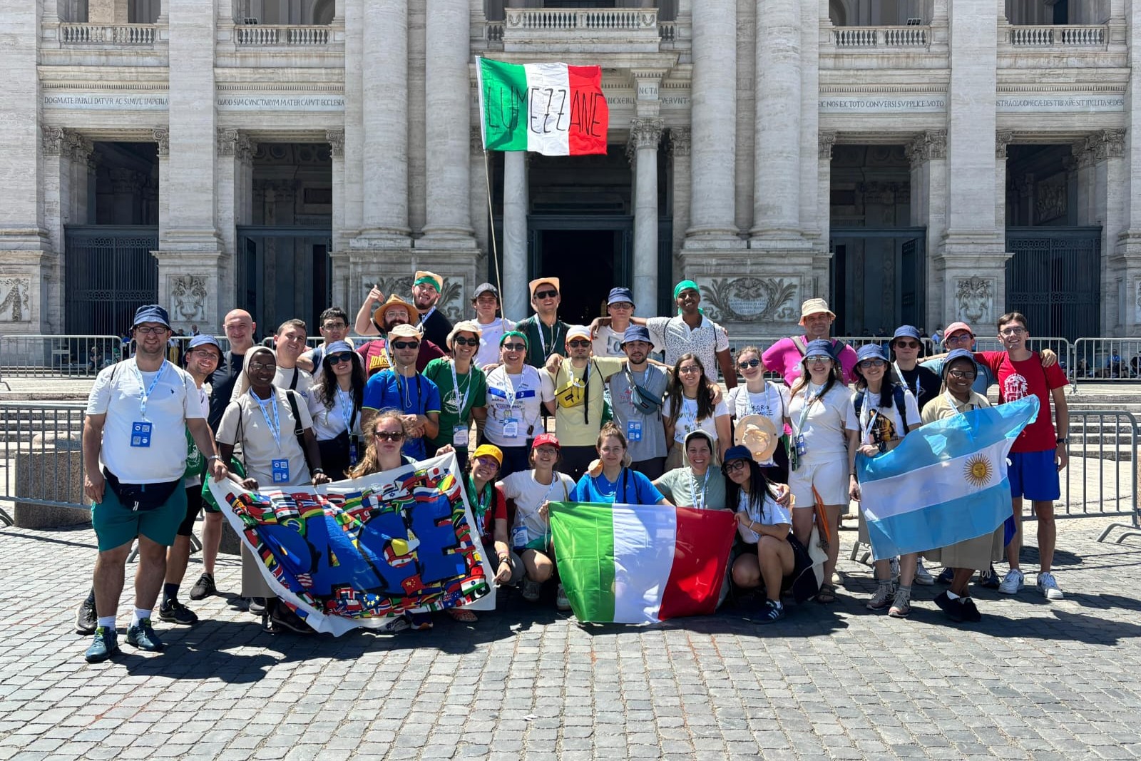 Jeanine Habarugira, Loredana Boniotti, Maite Fernández y Solange Bulangalire, junto a un grupo de jóvenes de la parroquia de Lumezzane, diócesis de Brescia, Italia, participan en el Jubileo de los Jóvenes durante el ingreso por la Puerta Santa de la basílica de San Juan de Letrán, en Roma, en agosto del 2025. (Foto: cortesía Loredana Boniotti)
