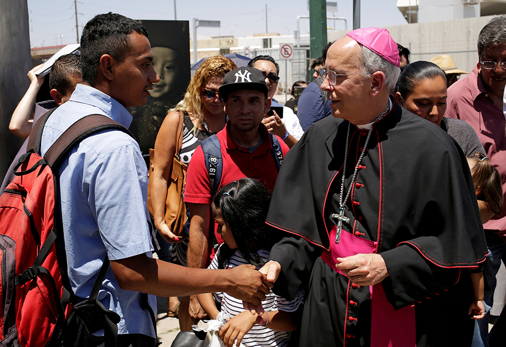 Bishop Mark J. Seitz of El Paso, Texas, greets a Salvadoran migrant in Ciudad Juarez, Mexico, June 27, 2019, who was deported after crossing the Paso del Norte international border from El Paso. (OSV News/Reuters/Jose Luis Gonzalez)