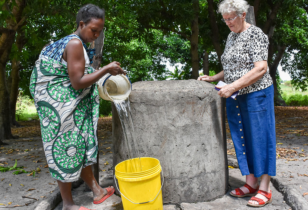 Chiyaze Biemba, left, and Presentation Sr. Cathy Crawford fetch water in one of the deep wells provided by the Sisters of the Presentation of the Blessed Virgin Mary in Singanda village at the edge of the Barotse floodplains in Mongu, Zambia. (Derrick Siliminia)