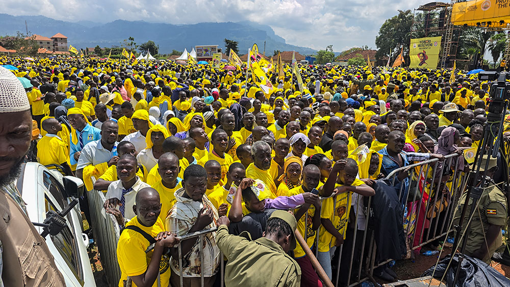 Supporters of National Resistance Movement presidential candidate Yoweri Kaguta Museveni gather at a campaign rally in Mbale City, eastern Uganda, on Nov. 10, 2025, wearing yellow party colors and waving flags as they await his address. (Gerald Matembu)