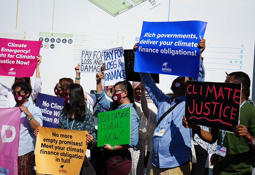 Climate justice activists hold placards demanding that wealthy nations meet their climate finance commitments during the 2022 COP27 climate conference in Sharm el-Sheikh, Egypt, calling for accountability and support for countries bearing the brunt of climate change. (GSR photo/Doreen Ajiambo)