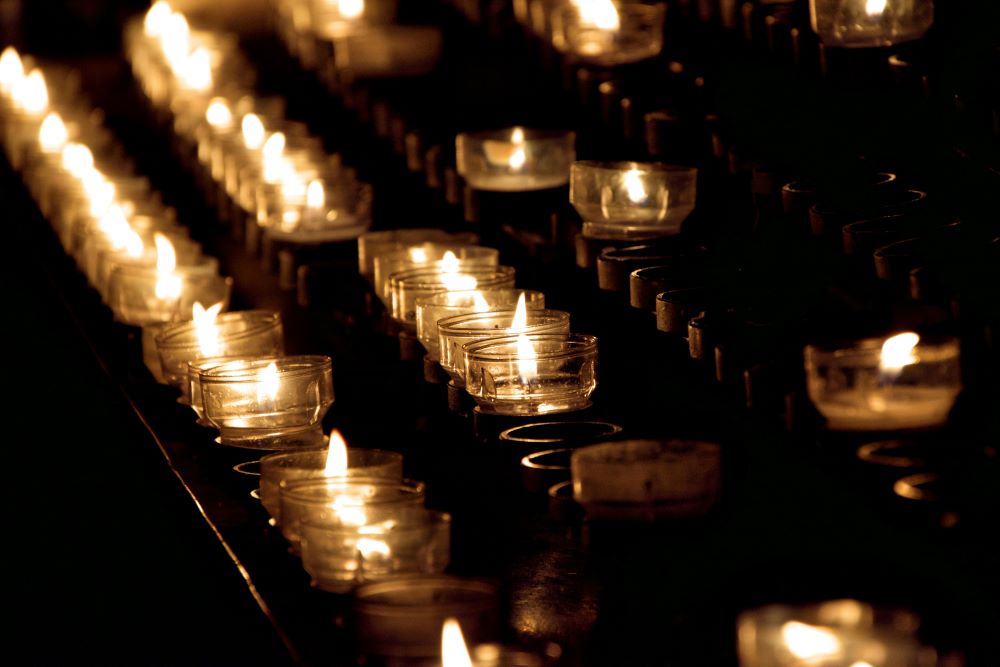 rows of lit votive candles
