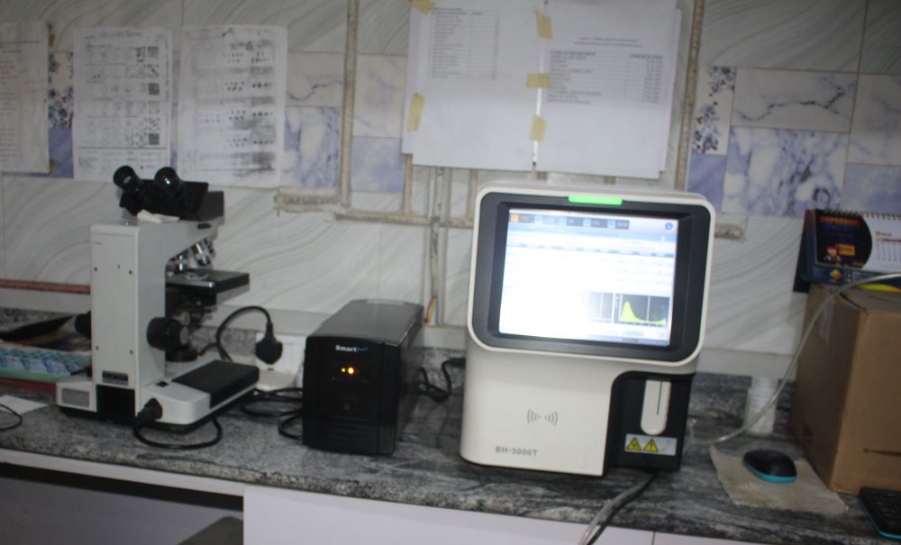 A microscope and a laboratory analyzer are used to perform tests and display the results digitally in the lab at Ancilla Catholic Hospital in Lagos, Nigeria. More than 97% of the hospital's HIV clients have achieved viral suppression, according to the hospital. (Valentine Benjamin)