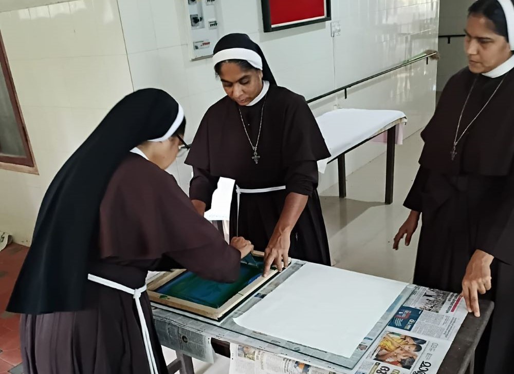 Sr. Ranit Pallassery, left, and Sr. Ancitta Urumbiland prepare a screen print to be used on bags while Sr. Alphy Pallassery looks on in their convent at Kuravilangad, southwestern Indian state of Kerala. (Courtesy of Ranit Pallassery)