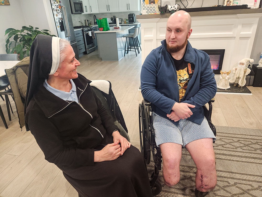 Vladislav Yaremenko, right, a Ukrainian army veteran is now living in a home with other Ukrainian soldiers in a Philadelphia suburb while undergoing rehabilitation. He is joined here by Ukrainian Sr. Dia Zagurska, a member of the Sisters of the Order of St. Basil the Great. (GSR photo/Chris Herlinger)