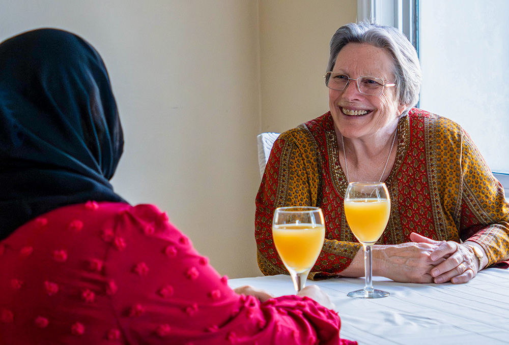 St. Joseph Sr. Sue Dunning, right, talks with a woman staying in the CSJ Shelter for Refugee Families, a ministry that sponsors and houses families in the immigration process. (Courtesy of the Sisters of St. Joseph of Orange)