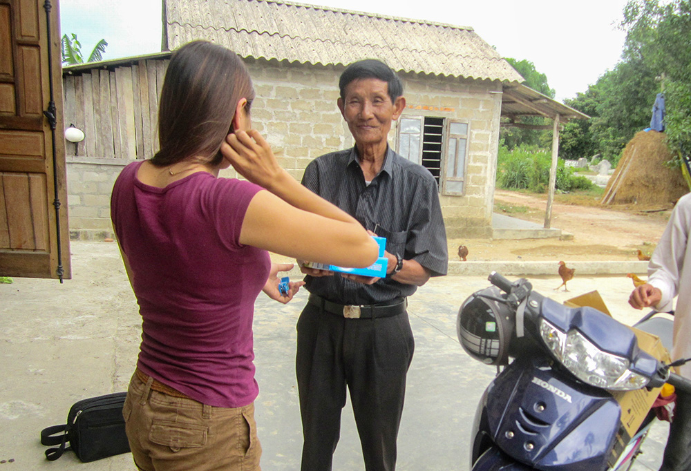Volunteer Bartholomew Phan Tu gives a care package to a woman living with HIV in Hue, Vietnam, on Sept. 27, 2025. (GSR photo)