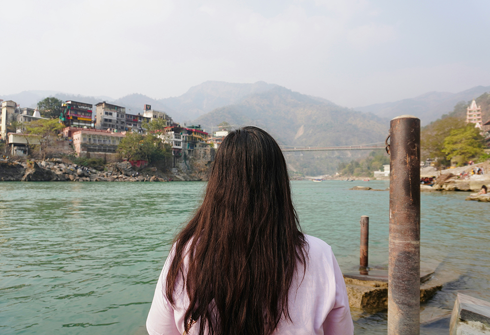 A woman looks out over a body of water. (Unsplash/Prashant)