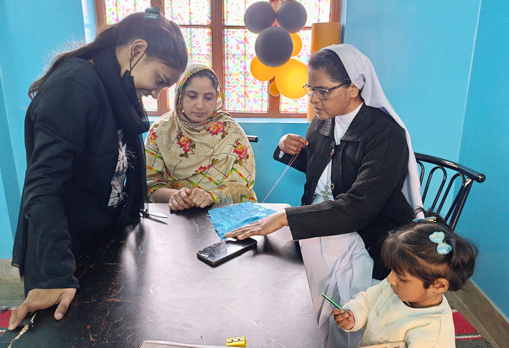 Sr. Cecilia Joseph teaches a trainee at the sewing center run by the Franciscan Tertiary Sisters of Lahore in Lahore, Pakistan. (Kamran Chaudry)