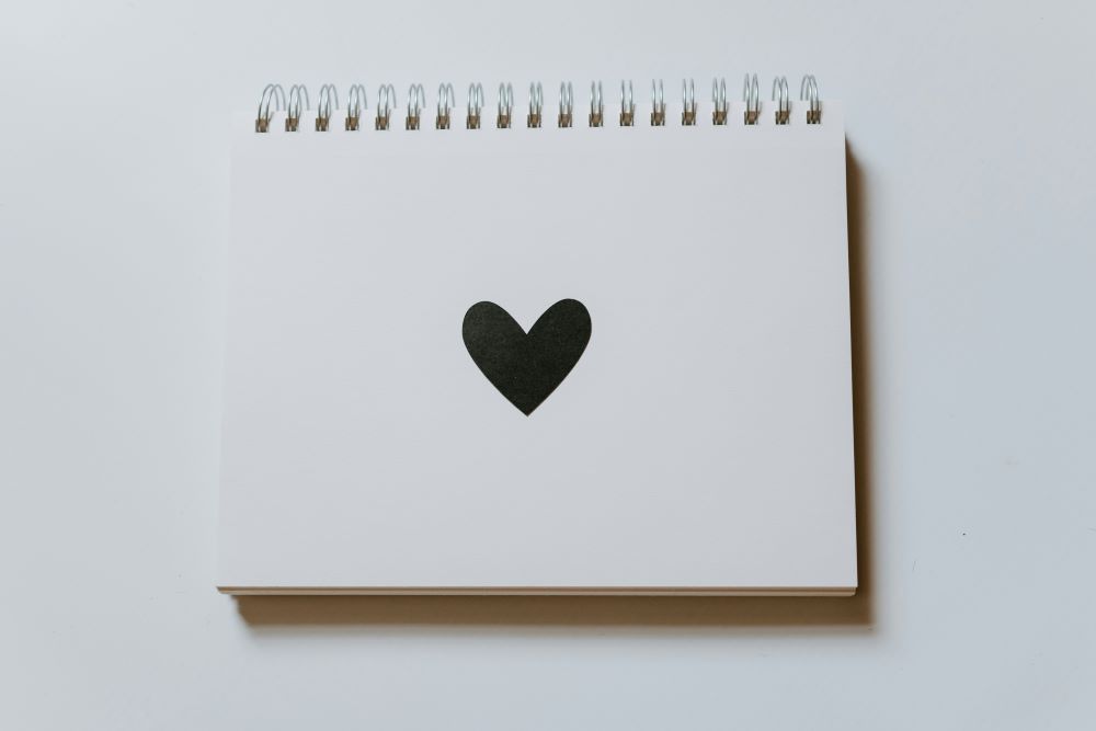 open notebook with black heart on page
