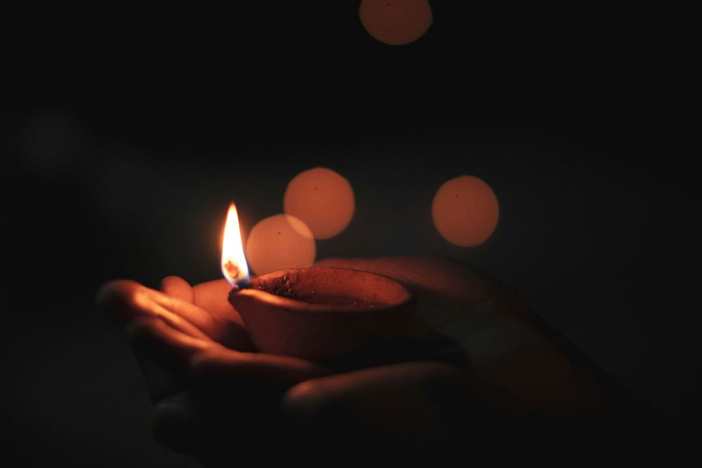 hands hold Diwali candle 
