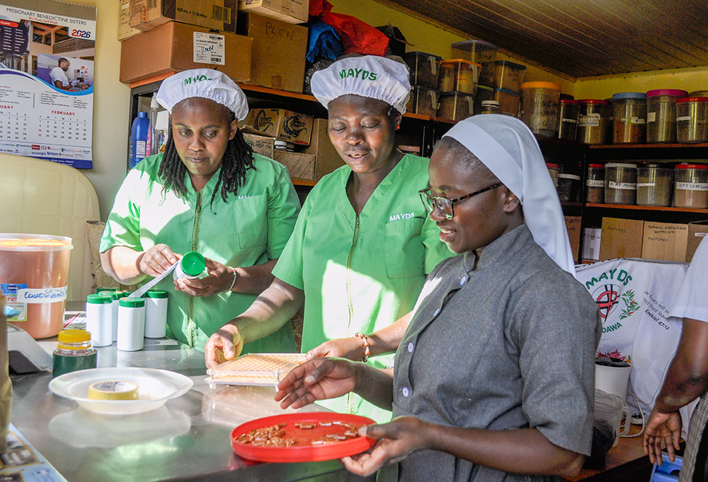 Sr. Mary Grace, a postulant of the Missionary Benedictine Sisters, and staff make cayenne pepper capsules at the Medicine at Your Door Step production unit  in Karen, Nairobi, Kenya. (Lourine Oluoch)