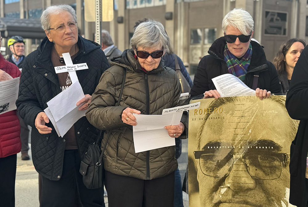 Franciscan Srs. Maria Orlandini and Marie Lucey, of the Franciscan Action Network, on the left, took turns reading the names of people deported, those who have died in ICE detention centers, and three U.S. citizens killed by federal agents outside the headquarters of the U.S. Immigration and Customs Enforcement March 24, 2026. They participated in an ecumenical event to mark the feast of St. Oscar Romero by calling attention to violent acts committed by ICE agents. (GSR photo/Rhina Guidos)
