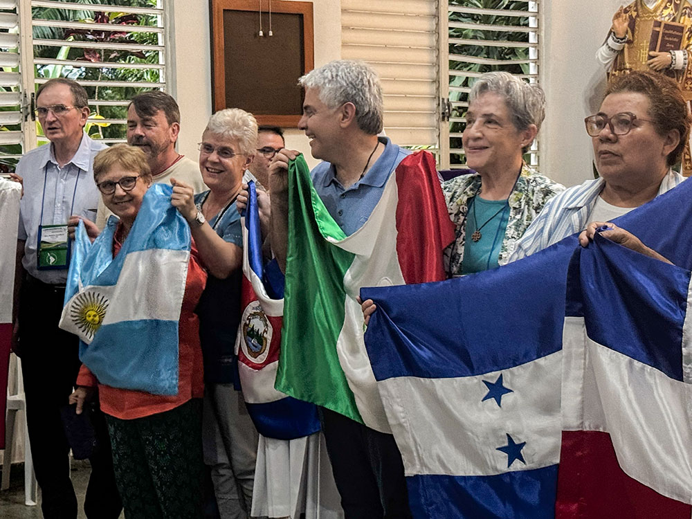 Miembros de la Confederación de Religiosas y Religiosos de América Latina y el Caribe, con banderas de los diferentes países de la región, cantan dentro de una capilla durante una reunión de la junta directiva el 21 de marzo del 2026 en la República Dominicana. La CLAR afirmó su compromiso con el proceso que el papa Francisco denominó un "caminar juntos", o la sinodalidad (Foto: GSR/ Rhina Guidos) 