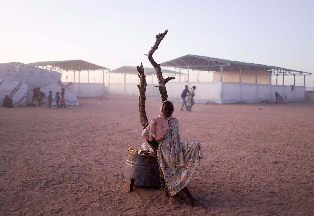 A Sudanese refugee girl from al-Fashir, Sudan, rests next to a burnt tree in the middle of the Tine transit camp in eastern Chad, Nov. 23, 2025, amid the conflict in Sudan between the paramilitary Rapid Support Forces and the Sudanese army. (OSV News/Reuters/Amr Abdallah Dalsh)
