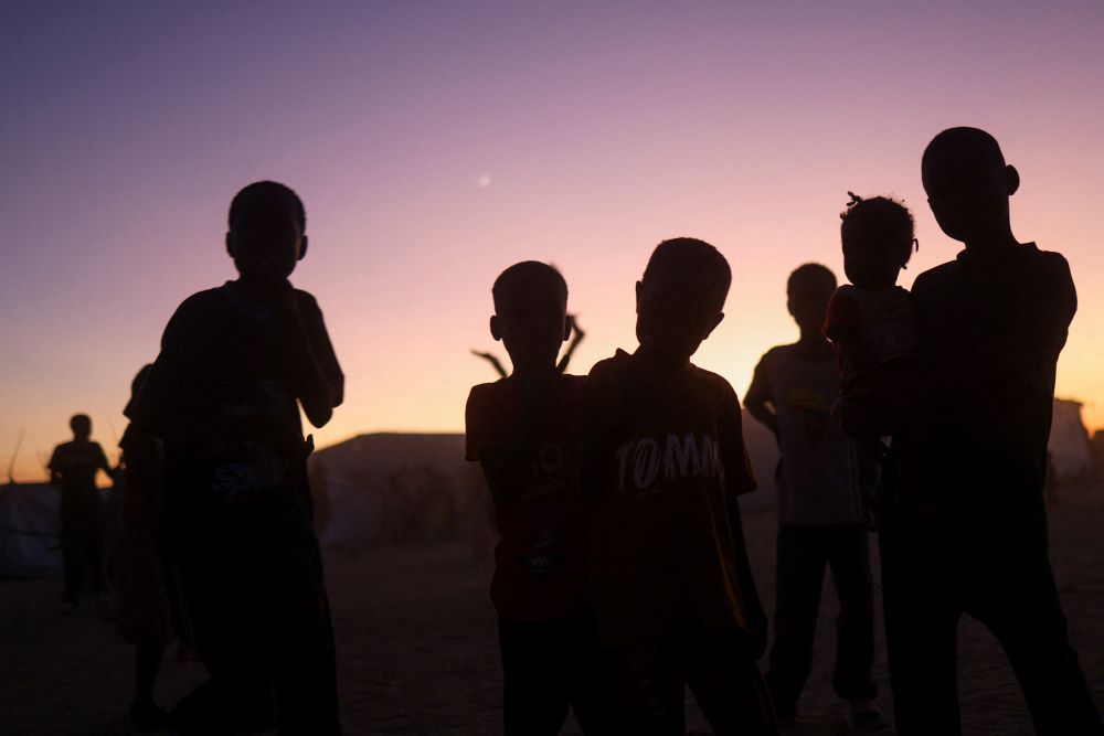 Sudanese refugee children from al-Fashir stand at sunset at the Tine transit refugee camp in eastern Chad Nov. 23, 2025, amid the ongoing conflict between the paramilitary Rapid Support Forces and the Sudanese army. (OSV News/Reuters/Amr Abdallah Dalsh)
