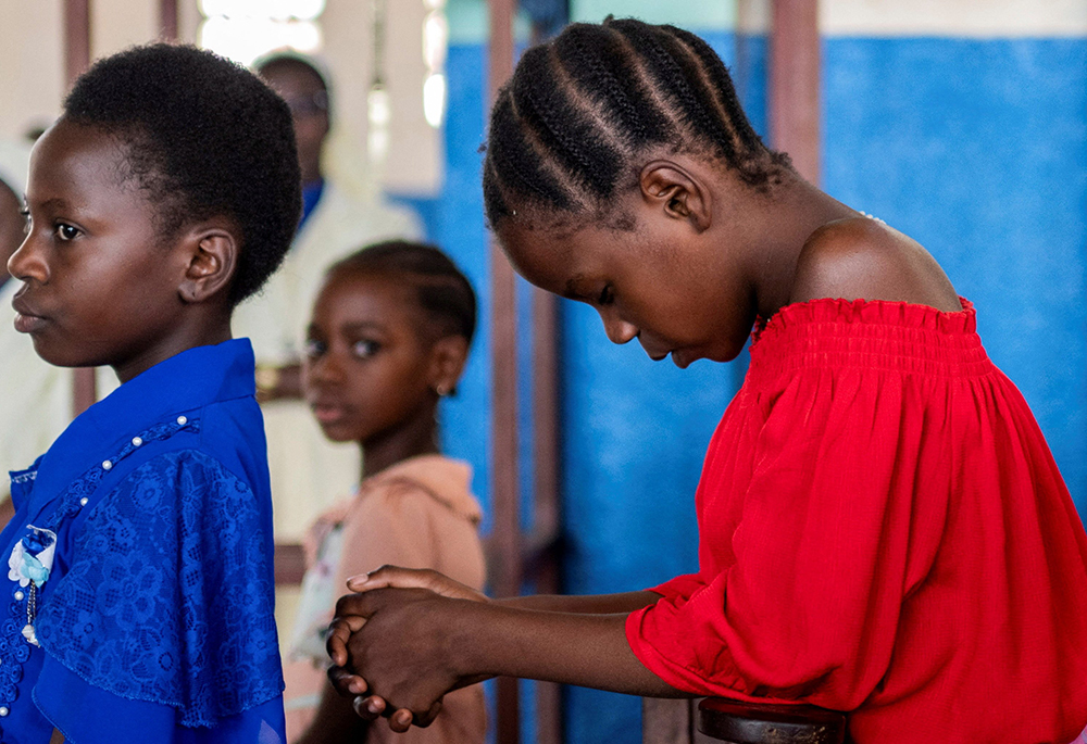 A girl prays during Mass at a Catholic church in Uvira, Congo, Dec. 14, 2025, after members of the Alliance Fleuve Congo AFC-M23 Movement took over the town from the Democratic Republic of the Congo, or FARDC. A climate of fear reigned Dec. 13 in Uvira, a strategic city in eastern Congo, days after it fell to the Rwanda-backed M23 group, as fighting in the region escalated despite a U.S. mediated peace deal. (OSV News/Reuters)