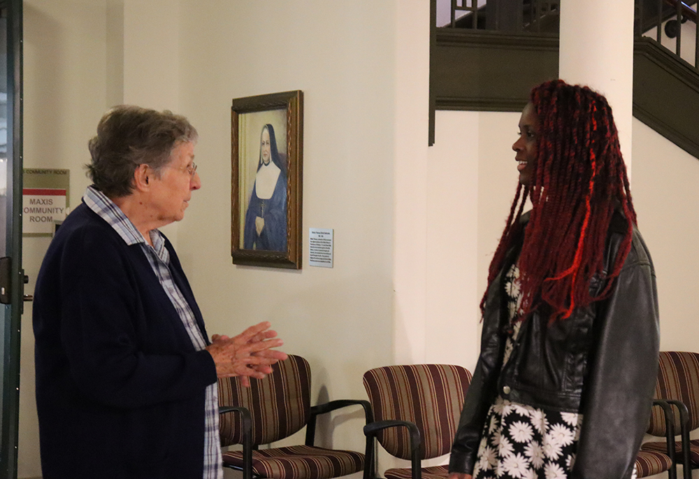 Sr. Ann Wisda, left, and Mattie Levy, community engagement coordinator for Prison Creative Arts Project, interact at the exhibition's opening reception. (Courtesy of Kameryn Gannon/IHM Sisters)