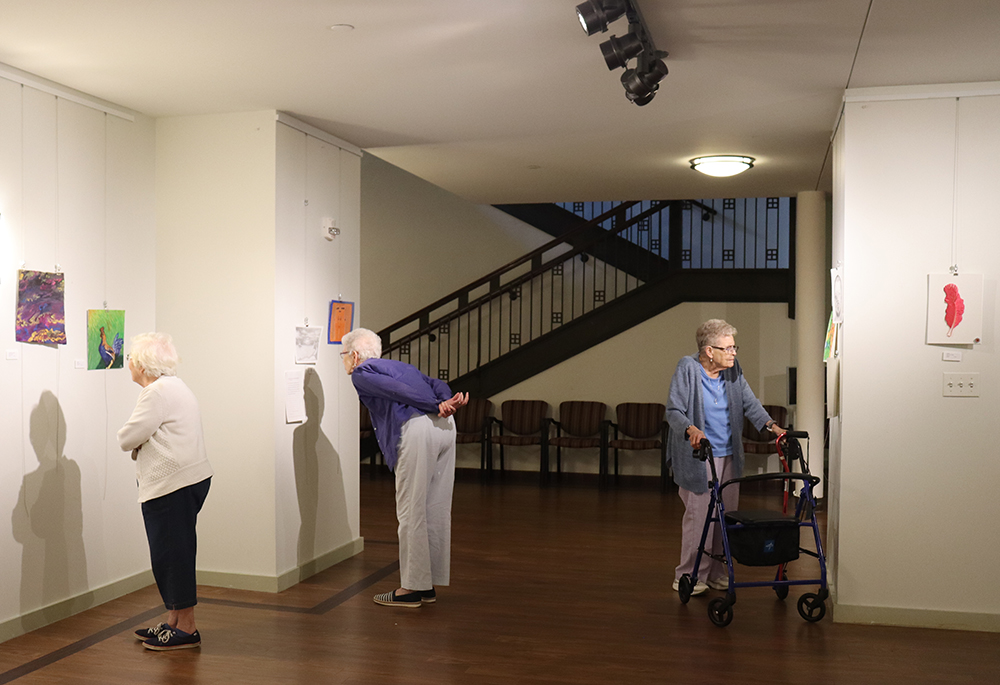 Srs. Betty Leon, Monica Stuhlreyer. and Judith Bonini view artwork on display at the Prison Creative Arts Project's exhibition at the Sisters, Servants of the Immaculate Heart of Mary's Motherhouse Gallery. (Courtesy of Kameryn Gannon/IHM Sisters)