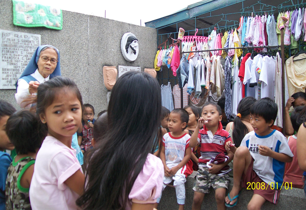 Children living inside a Manila cemetery gather during one of Sr. Evangelina Canag's early visits in 2008. (Courtesy of Daughters of St. Paul)