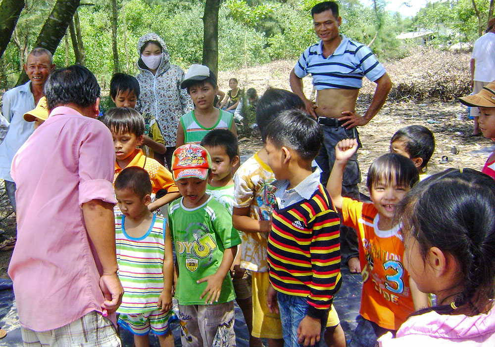 Parents watch their children with autism play games during a beach trip organized by the Lovers of the Holy Cross sisters in Vietnam on Sept. 13, 2025. (Joachim Pham)