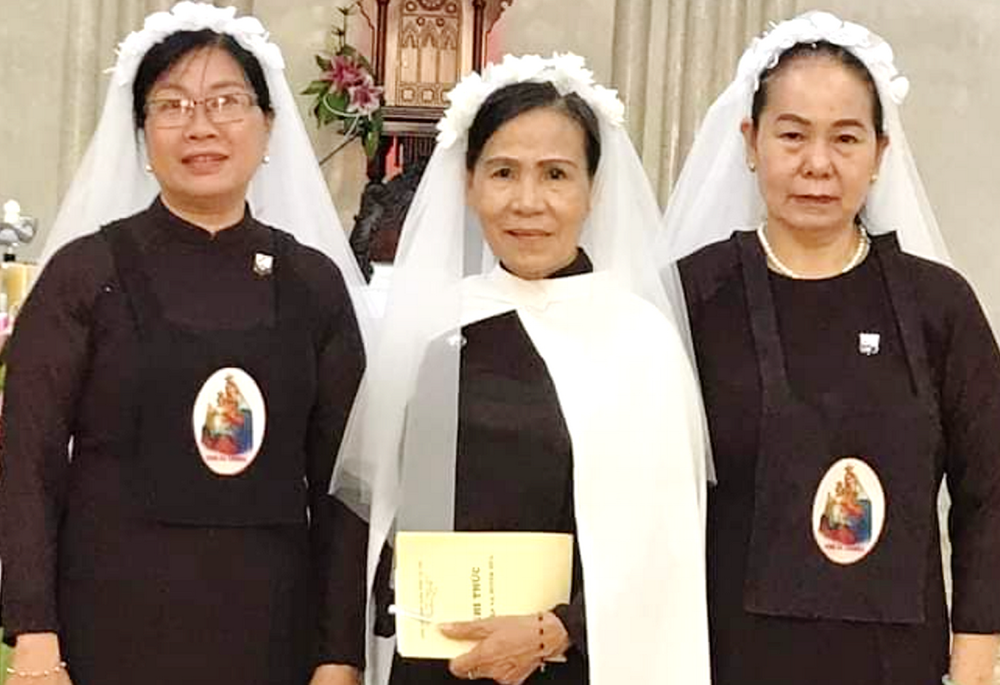 Maria Madeline Do Thi Ngoc, center, and two other lay Carmelite members pose for a photo in their vow-taking ceremony in Hue, Vietnam, on March 19, 2025. (Joachim Pham)