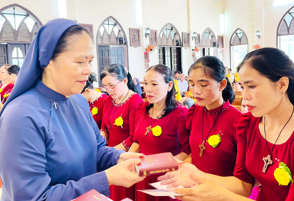 Lovers of the Holy Cross Sr. Maria Madelene Le Thi Bich offers Bibles to newcomers to the group of former sisters in Hue, Vietnam, on Sept. 14, 2025. (Joachim Pham)