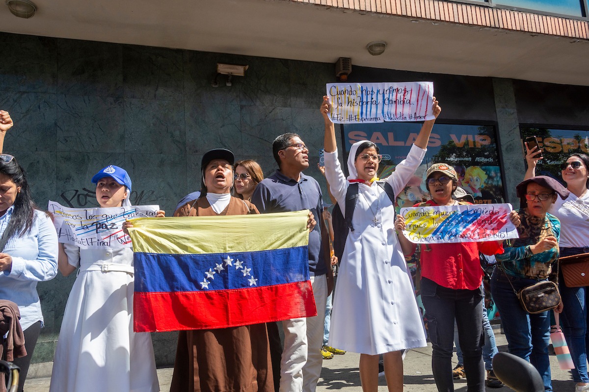 Hermanas participan en una concentración en la calle Elice de Chacao, Caracas, el 9 de enero de 2025, víspera de la toma de posesión de Nicolás Maduro para su tercer período. Sus pancartas proclamaban: "Cuando nos unimos la historia cambia", "Cuando muere el miedo nace la libertad" y "Dichosos los que trabajan por la paz". (Foto: Jimmy Villalta)