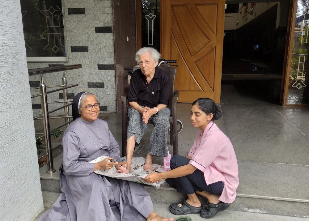 Sr. Suchita Kavumkal, a staff member at Elizabeth Care Home in Bengaluru, southern India, managed by the Augustinian Sisters, helps care for Jessie Pai, an 88-year-old resident. (George Kommattam)