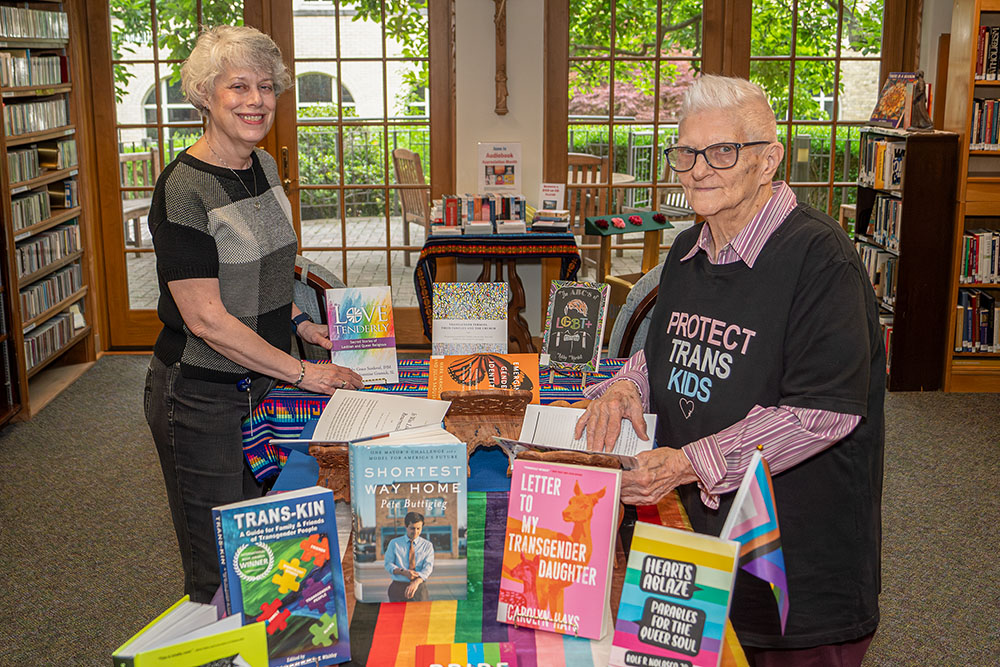 Linda Diltz, left, and Holy Cross Sr. Suzanne Patterson prepare the June Pride Month display of books in the St. Mary's Convent Library in Notre Dame, Ind. (Courtesy of Hugo Garza)