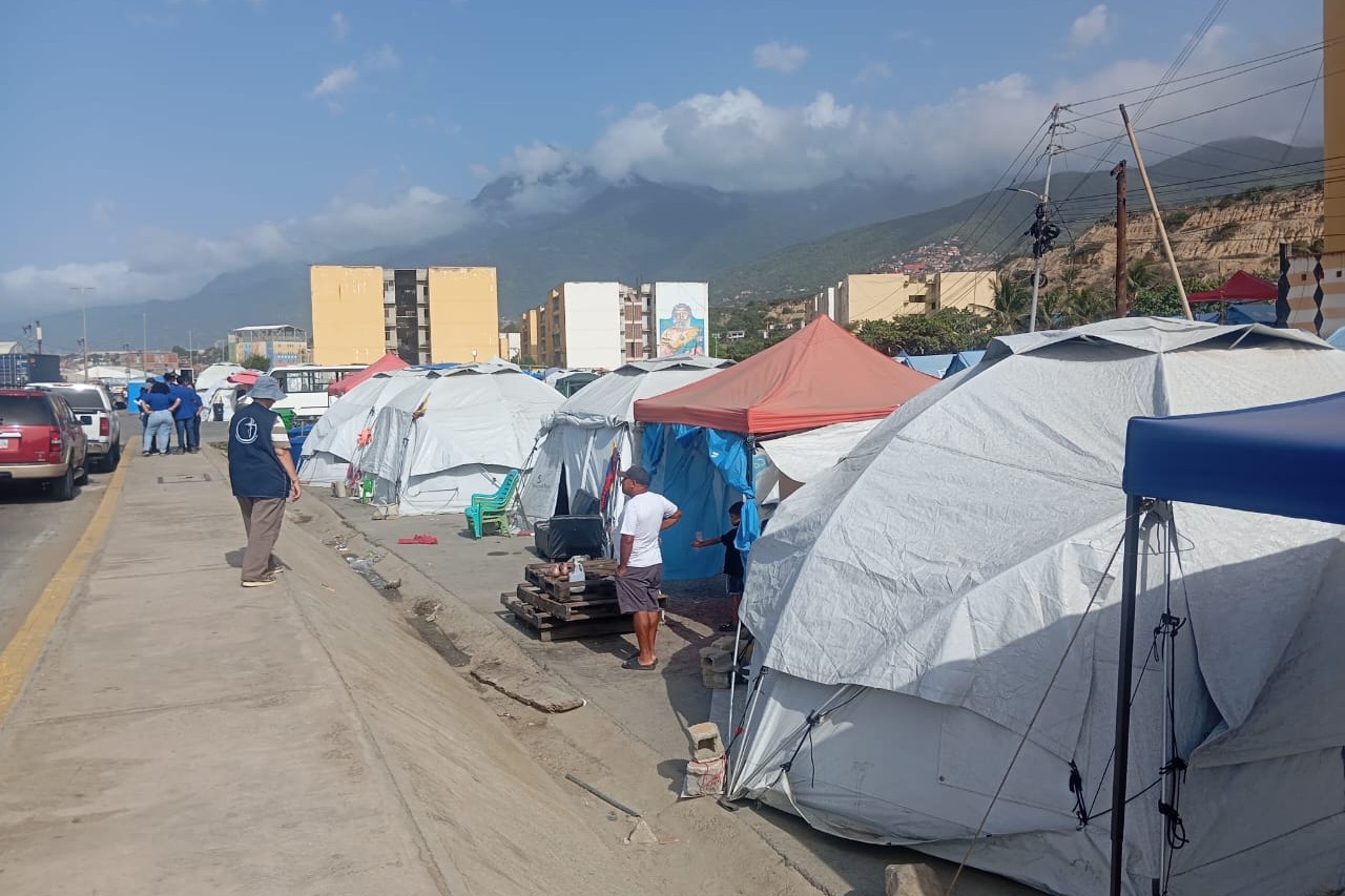 En las visitas a los campamentos temporales, como este en Los Corales, estado La Guaira, la Hermana Gisela Reich acompaña a quienes, desde el terremoto de junio de 2026, permanecen en casas de campaña. (Foto: cortesía Carmen Camacho)