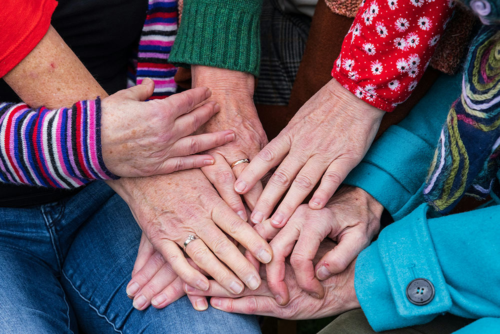 Hands of a group of older women (Unsplash/Filipp Romanovski)
